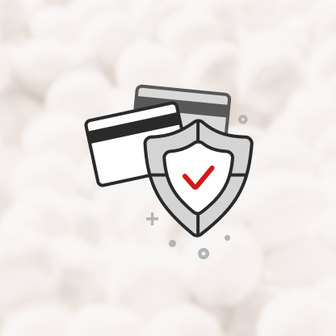 Two credit cards next to a gray shield with a red checkmark, symbolizing secure payment.